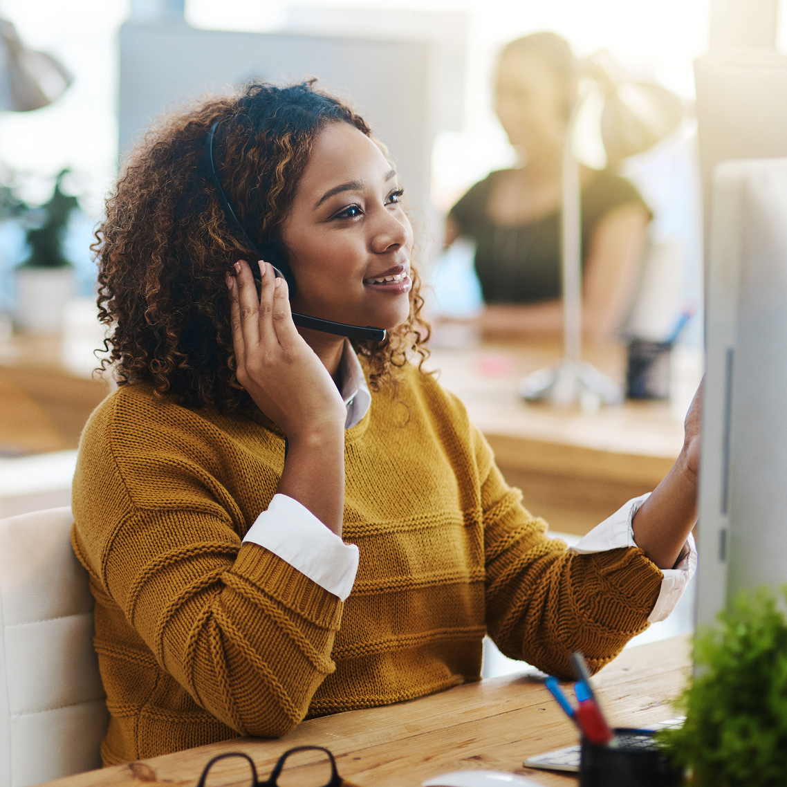 A customer service agent on the phone at her desk